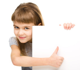Fototapeta premium Little girl is looking out from the blank banner