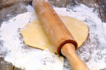 rolling pin and dough on a wooden table