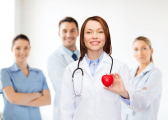 smiling female doctor with heart and stethoscope