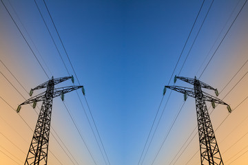 Electric power lines against blue and yellow sky