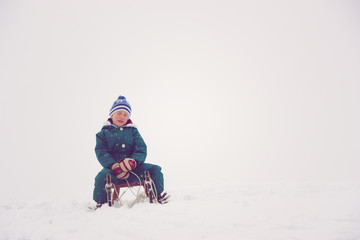 Fototapeta na wymiar Child siting on his sleigh