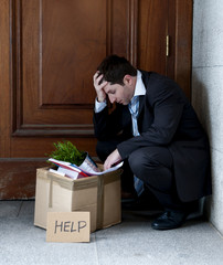 frustrated business man on street fired carrying cardboard box