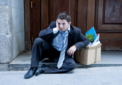 frustrated business man on street fired with cardboard box