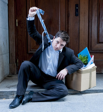 frustrated business man on street fired with cardboard box
