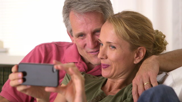 Senior couple taking photos on smartphone