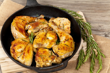 Frying pan with chicken, garlic and rosemary