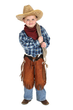 Cute young cowboy stnading smiling holding a rope