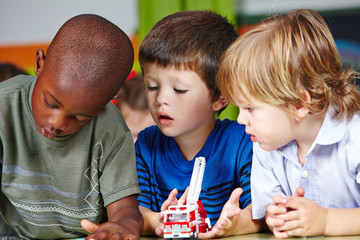 Jungs spielen zusammen im Kindergarten - obrazy, fototapety, plakaty