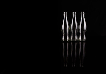 Empty bottles over black background