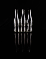 Empty bottles over black background