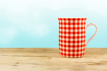 Red cup on wooden table.