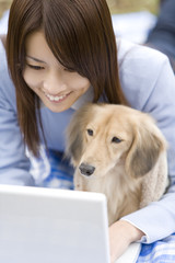 woman looking at PC with dog
