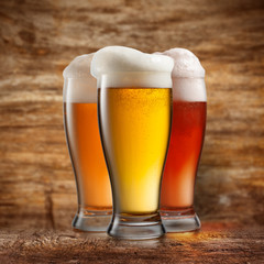 Different beer in glasses on wooden background