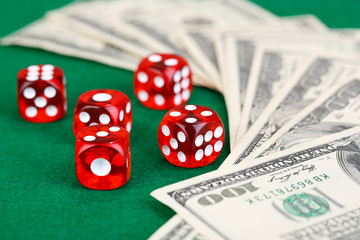 Red dices and dollars on green background