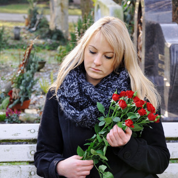 Frau trauert auf Friedhof