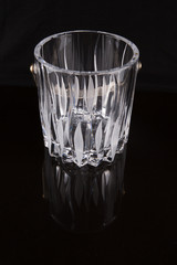 Empty crystal ice bucket over black background