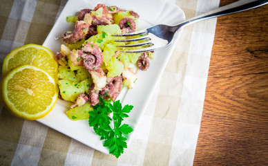 Octopus salad with lemon slice and potatoes with parsley