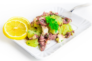 Octopus salad with lemon slice and potatoes with parsley