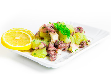 Octopus salad with lemon slice and potatoes with parsley
