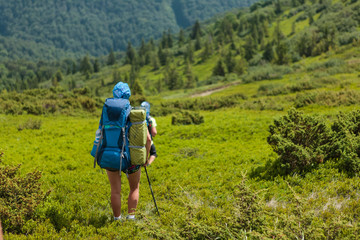 Young people are hiking in Carpathian mountains in summertime