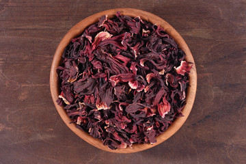 Obraz na płótnie Canvas Dried petals of hibiscus in a wooden bowl