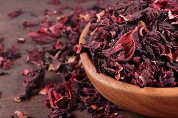 Dried petals of hibiscus in a wooden bowl