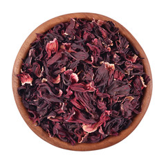 Dried petals of hibiscus in a wooden bowl on a white