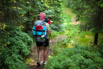 Young people are hiking in deep forest in summertime