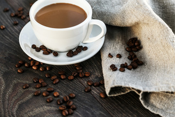 A cup of white coffee with beans and linen cloth