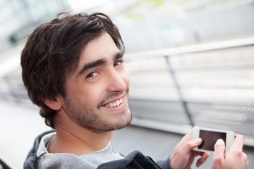 Young relaxed man writting text in the street