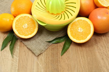 Obraz na płótnie Canvas Citrus press and fruits on wooden background