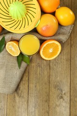 Obraz na płótnie Canvas Citrus press and fruits on wooden background