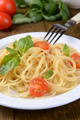 Delicious spaghetti with tomatoes on plate on table close-up