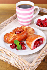 Fresh baked pasties with cherry on plate on table close-up
