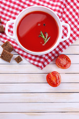 Tasty tomato soup on wooden table