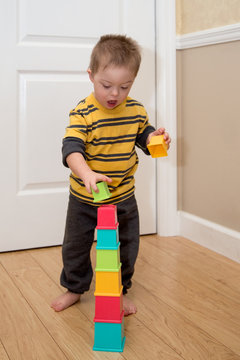 Down Syndrome child playing with stacking toy