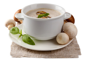 Mushroom soup in white bowl, on napkin, isolated on white