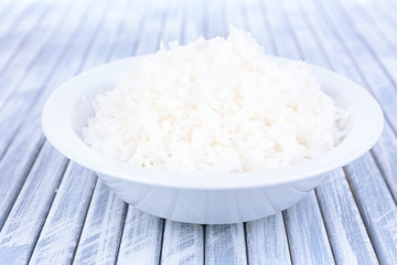 Cooked rice in bowl on wooden background
