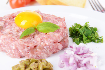 Delicious steak tartare with yolk on plate on table close-up