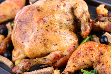 Whole roasted chicken with vegetables on tray, close-up