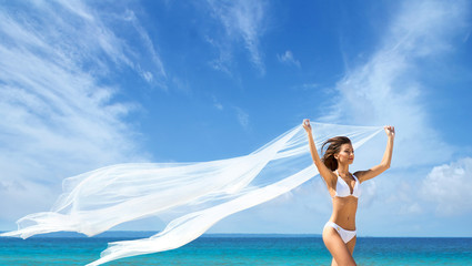 A beautiful woman in a swimsuit posing with a silk blanket on th