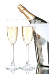 Glasses of champagne and bottle in pail, isolated on white