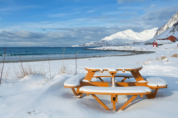 Picnic round table on a snowy beach - 61995991