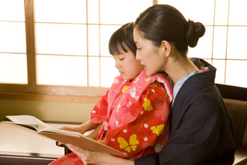 parents and child in yukata reading book