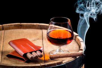Cognac in a glass on wooden barrel