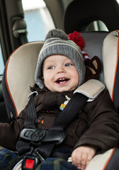 happy little boy in car seat
