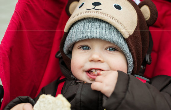 happy baby boy sitting in a red stroller