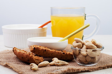 Orange juice and two bowls with bread and nuts