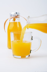 Pouring orange juice into a transparent cup