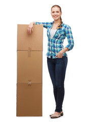 young woman standing next to tower of boxes